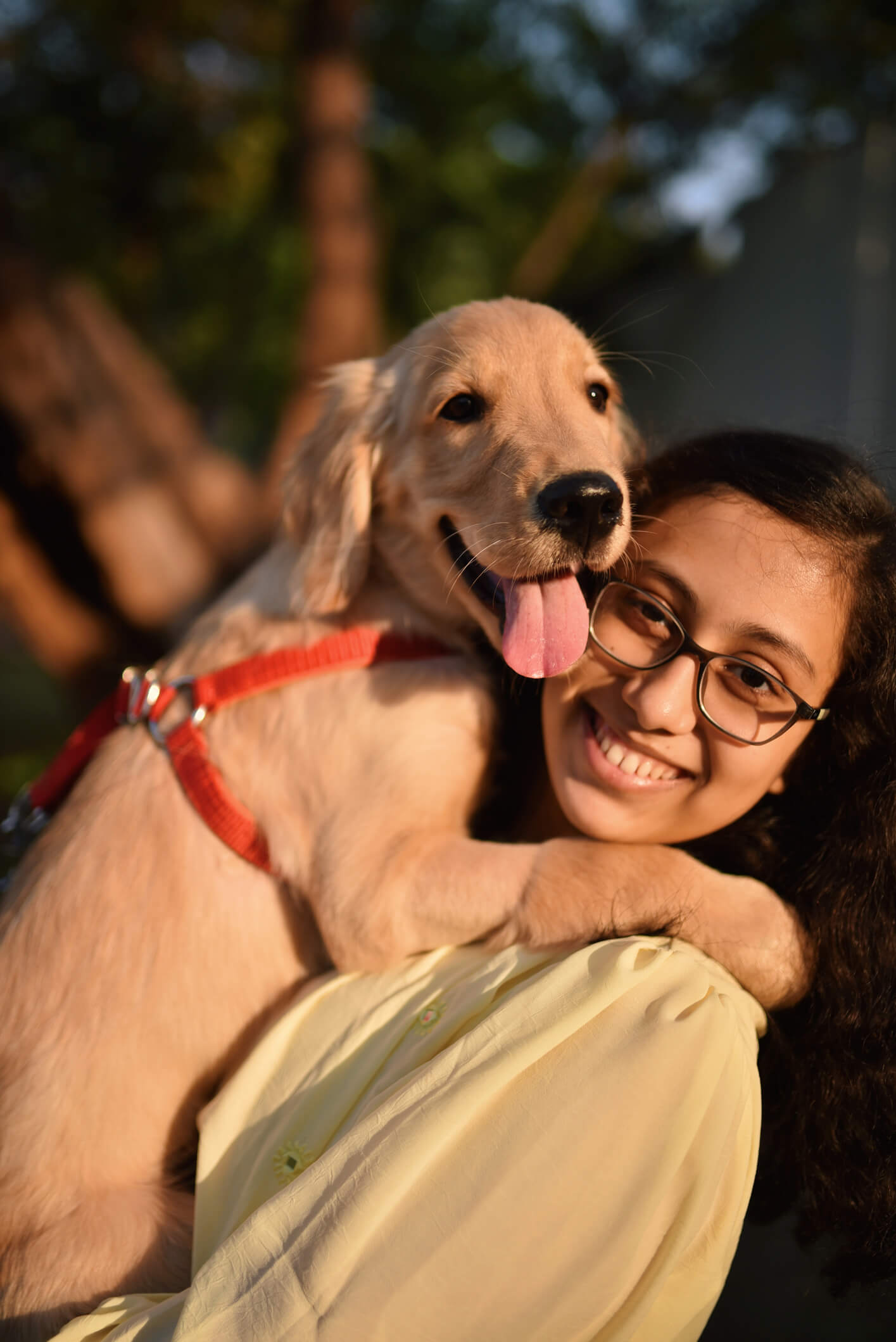 Girl cuddling and holding her pet dog in her arms