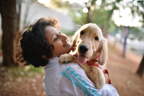 Girl with her golden retriever puppy